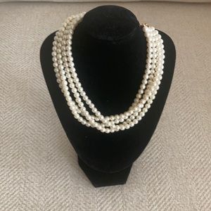 White costume pearls, 4 rows with gold tone closure.